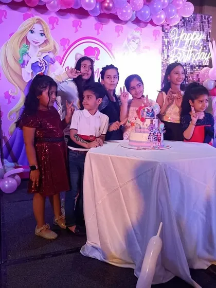 The cake-cutting ceremony is always a highlight. Here are the kids gathered around the beautiful Barbie cake, excited to celebrate with the birthday girl.