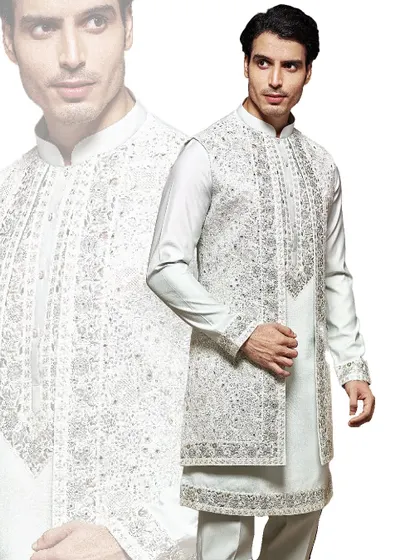 The essence of royal charm. This heavily embroidered sherwani in a subtle off-white is a masterpiece of our craftsmanship, designed for the groom who wants to make a grand, traditional statement.
