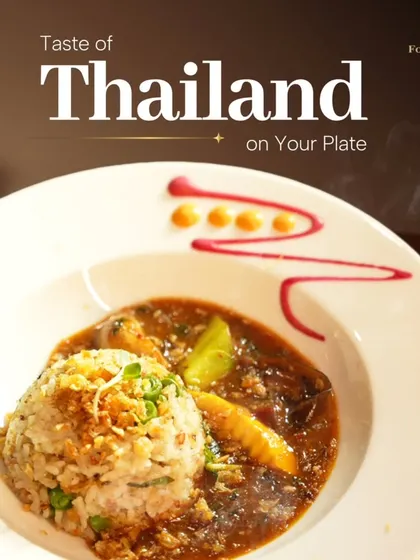 A taste of Thailand on your plate. This dish features fragrant rice with a savory Thai curry, garnished with fried onions and artistically plated to be as beautiful as it is delicious.