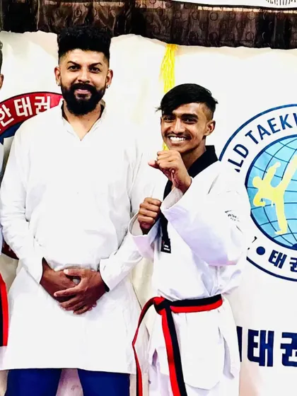 A student smiles after earning his red and black belt.