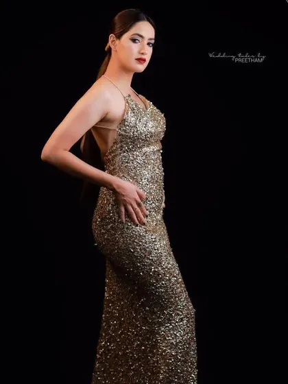 A full-length side profile of the gold gown, showcasing its beautiful silhouette and how it hugs the body.