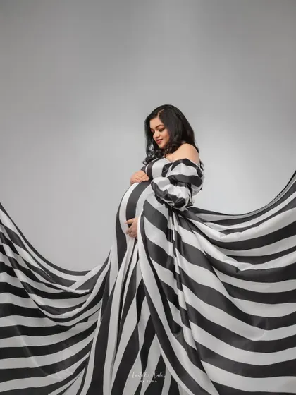Inspired by high fashion, created for motherhood. This couture-inspired look with its bold stripes and dramatic flow is for the mother who sees her journey as a masterpiece. We will work together to create a concept that is as unique and iconic as you are.