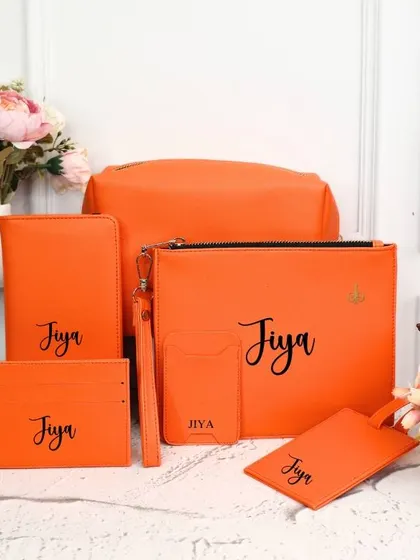 For those who love a pop of color, this travel kit in a bright orange is a perfect choice. The personalized set includes all the essential accessories for your journey.