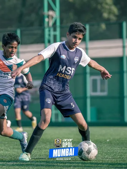A player shields the ball, using his strength to hold off a challenger.