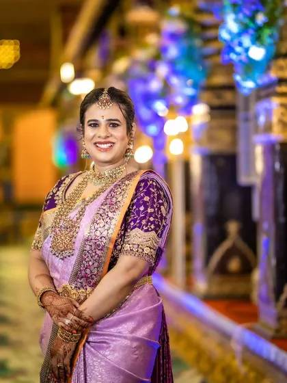 Anusha looking radiant at her son's naming ceremony. The heavy zardosi work on her purple blouse perfectly complements her temple jewelry.