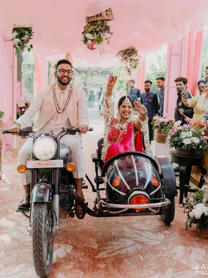 A cool and quirky entry, with the couple arriving on a Royal Enfield motorcycle with a sidecar, waving to their guests.