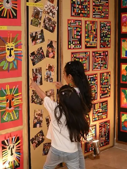 Students exploring the gallery walls, pointing out their friends' work and their own. Our exhibition is a truly interactive and inspiring event for the children.