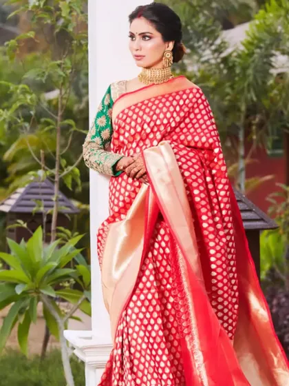 A full portrait of the bride in her gorgeous red reception saree. The makeup, hair, and styling all come together to create an image of pure elegance and grace.