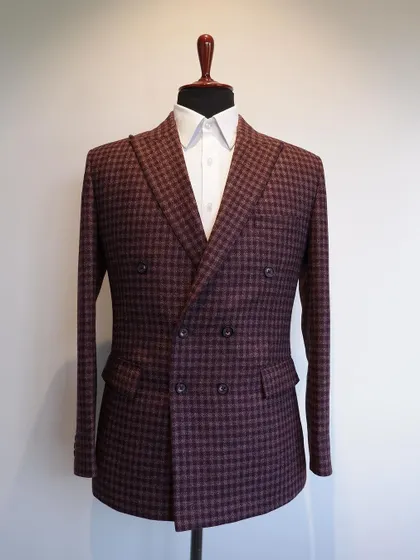 This classic double-breasted jacket in a maroon check flannel wool is a gentleman's pick for the cooler seasons.