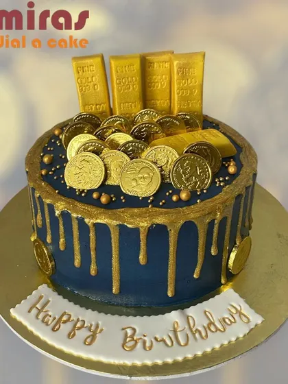 A cake that looks like a pile of treasure. This navy blue drip cake is loaded with edible gold bars and coins, making it a rich and decadent centerpiece for a birthday.