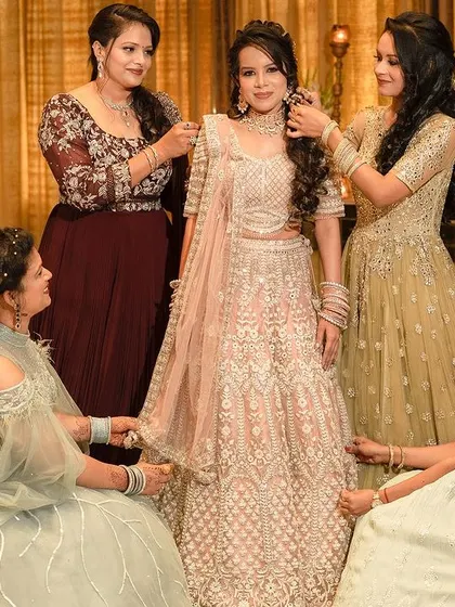 A heartwarming behind-the-scenes moment as the bridesmaids help the bride with her final touches before her engagement ceremony.