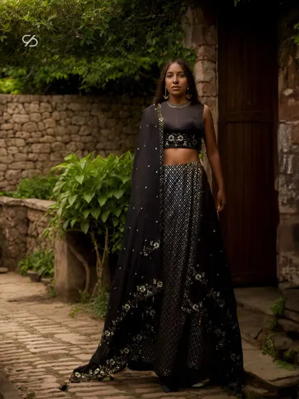 Unveil the allure of tradition with a touch of modern mystique. This black lehenga, with its silver embellishments and floral details, is perfect for an evening celebration.