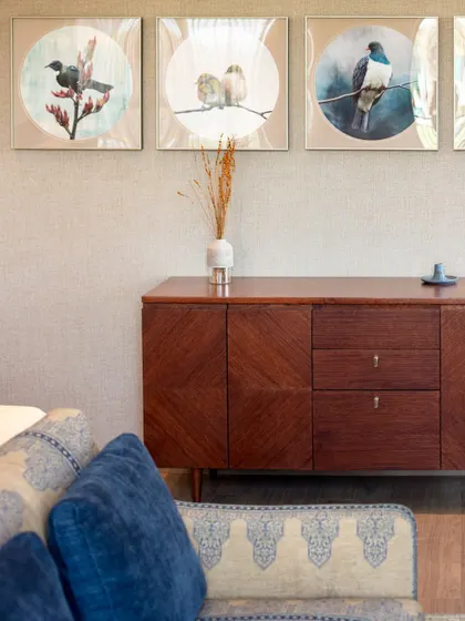 A closer look at the curated details. The patterned upholstery of the sofa and the rich wood of the console are complemented by the delicate bird artwork, creating a harmonious blend of color, texture, and nature-inspired motifs.