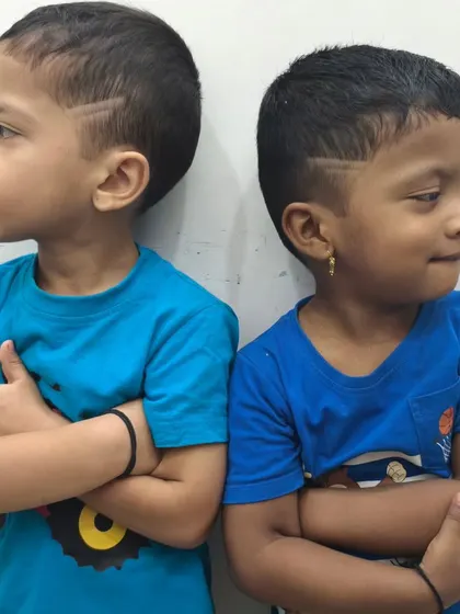 Double the style, double the swag. These two brothers are showing off their matching haircuts with cool side designs.