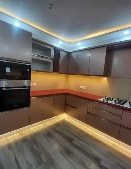 Another view of the spacious kitchen, highlighting the glossy cabinet finish and integrated appliances.