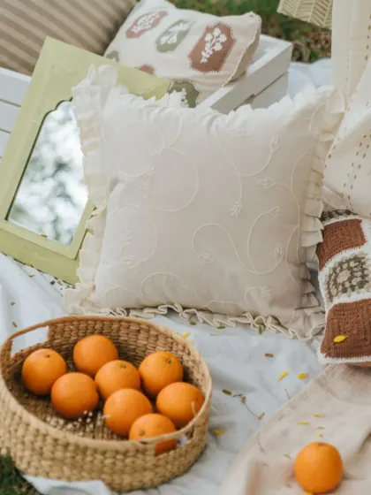 A close-up of our white cushion cover with delicate vine embroidery and ruffled edges. This piece adds a touch of vintage elegance and texture to any cushion arrangement.