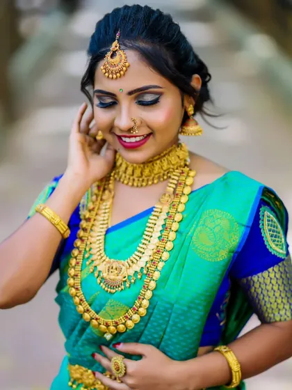 A happy bride enjoying her moment. The makeup features a subtle smokey eye and a classic red lip, a timeless combination for any South Indian wedding ceremony.