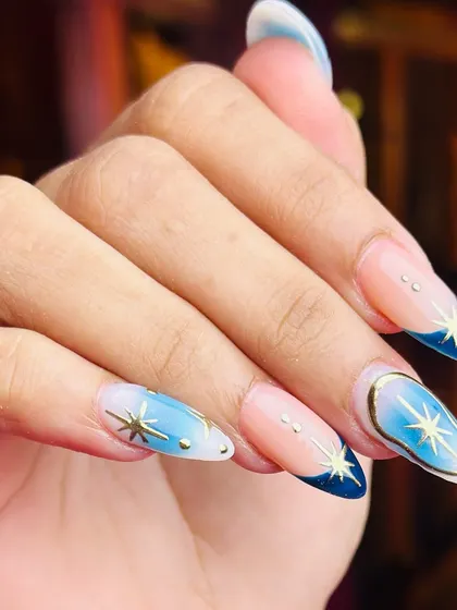 A celestial-inspired design with a blue ombre base and gold starburst accents. This look is dreamy, magical, and beautifully detailed.