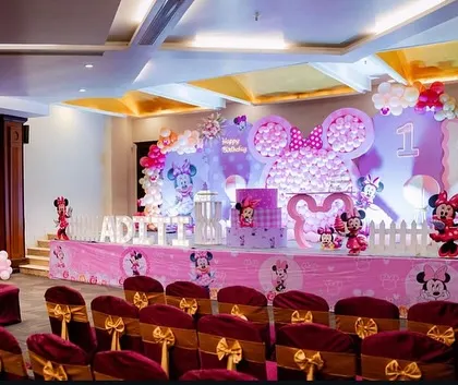 A full stage setup for a grand Minnie Mouse first birthday party. We created a massive Minnie head silhouette with pink balloons as the centerpiece, complemented by themed banners, props, and lighting.