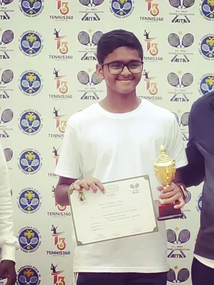 The Boy's Singles Winner of the AITA TS7 U-14 tournament, Niyant Vikas, poses with his trophy and certificate.