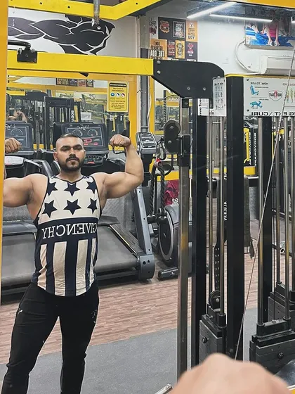A classic front double biceps pose in the mirror. This is a great way to assess arm size, symmetry, and overall upper body development.