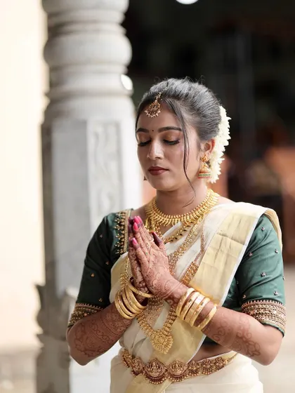 A serene moment of the bride in prayer. Her makeup is soft and understated, allowing for a moment of quiet reflection.