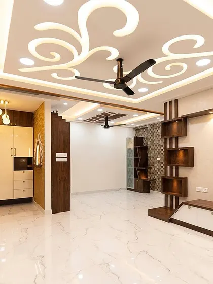 Another view of the living room with the ornate false ceiling design. This angle shows how the custom shelving unit balances the space and provides a stylish area for decor.
