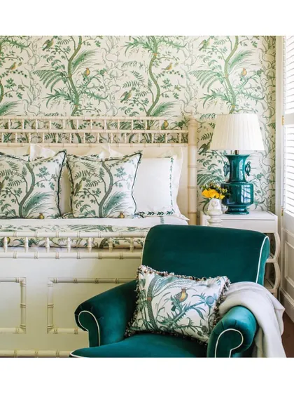 A monochromatic green palette can be incredibly dynamic. Here, a botanical wallpaper is paired with matching fabrics on the pillows and a velvet armchair, creating a layered, cohesive, and refreshing bedroom retreat.