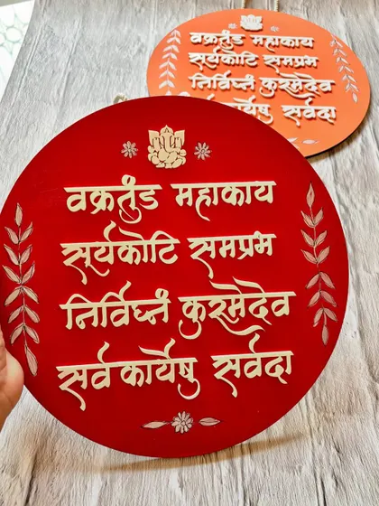 This circular wall hanging features the powerful 'Vakratunda Mahakaya' Ganesha shloka, designed to remove obstacles and bring good fortune.