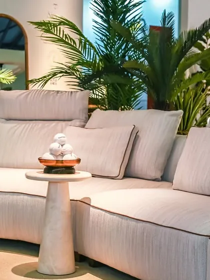 A close-up of the Montserrat Sofa, showcasing its soft, white fabric upholstery and contrasting piping. The design is reminiscent of the clouds surrounding the Montserrat mountains, bringing a sense of calm and refined comfort to your living space.