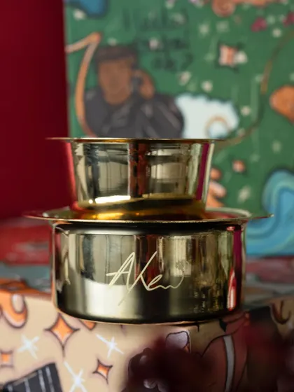A detail shot of the personalized brass coffee filter, a unique and practical gift included in the wedding return hampers.