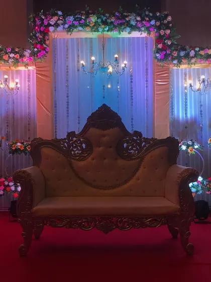 A similar stage setup, but with a gold-carved sofa and dramatic blue and purple lighting to create a different, more regal mood.
