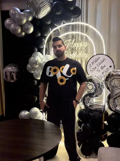 The birthday boy posing with his modern black and silver party decor. We love creating setups that reflect our clients' personal style.