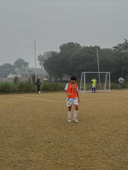 A young player on our full-size grass pitch during a training match. We provide a professional environment for players to develop from a young age.