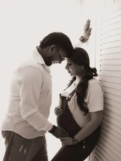An emotional and intimate black and white portrait. The couple shares a quiet moment, their connection beautifully highlighted by the soft, directional light.