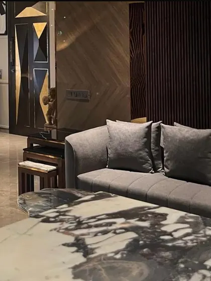 We believe luxury is found in the details. This composition from a Juhu apartment highlights a custom marble coffee table, the rich texture of the sofa, and a bespoke geometric door, demonstrating our commitment to curated, high-quality finishes.