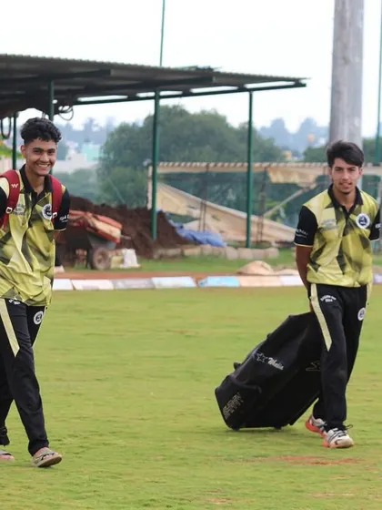 Players with their kit bags walk across the ground, ready for the next challenge.