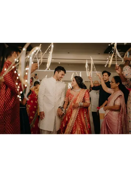 The grand entrance of the newly engaged couple, walking under an arch of sparkling fairy lights held by their loved ones. A truly magical moment.