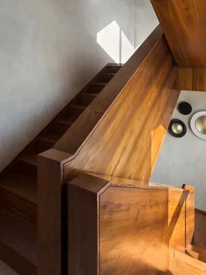 This impressive dog-legged staircase in the House of Terraces is clad entirely in rich Burma teak, serving as a central, grounding feature that connects all floors of the villa.