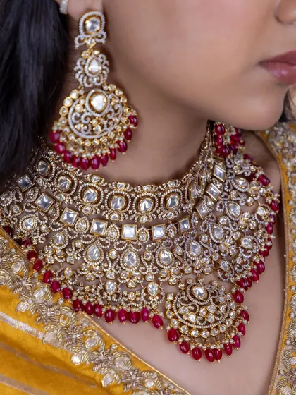 A detailed look at the craftsmanship of our red Kundan bridal choker. The combination of uncut stones and red beads creates a rich, textured look perfect for a wedding ceremony.