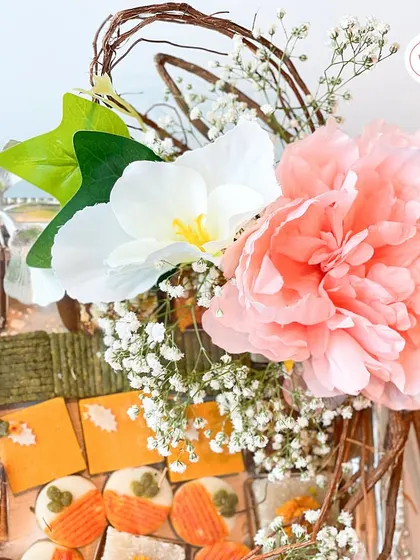 Another angle of the assorted mithai tray, highlighting the beautiful floral arrangement that gives the hamper a sense of occasion. The presentation makes the gift of sweets feel truly luxurious.