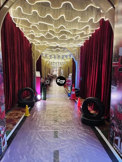 Guests walked through this incredible tunnel to enter the party. Lined with red velvet drapes, tires, and glowing ceiling lights, it felt like stepping right onto a Formula 1 track.