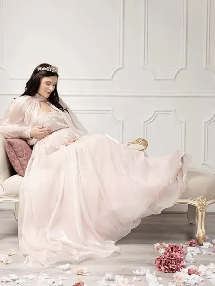 This is more than a photograph; it's a story of royalty, grace, and the magnificent journey of motherhood, captured in a timeless Victorian-inspired setting.
