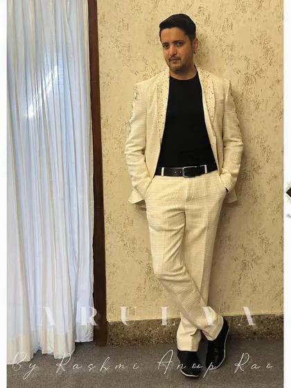 The final look of the off-white linen suit on Ammith Rao. It's styled here with a simple black t-shirt, showing how a custom suit can be dressed down for a smart-casual event.
