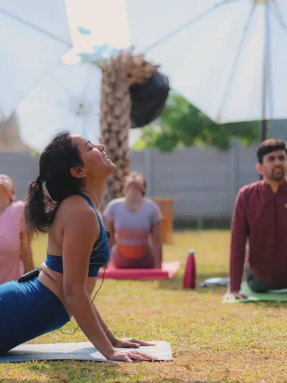Participants in our outdoor yoga session, finding their balance in the fresh air under our shaded umbrellas.