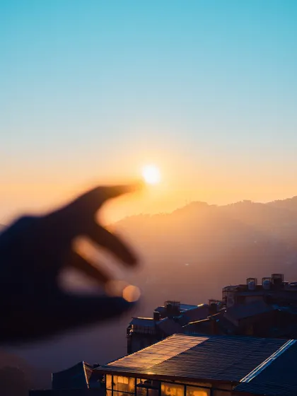 A creative shot of my hand appearing to hold the setting sun over Shimla. It's a playful way to interact with the landscape.