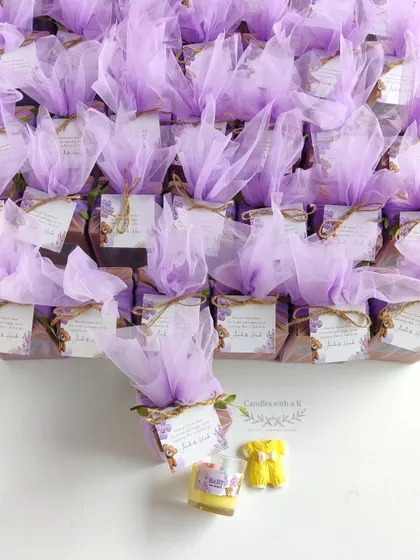 The full set of 25 personalized gift boxes, wrapped in lilac net, showcasing the teddy bear theme for a baby shower.