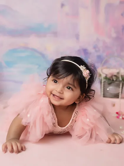 Half-birthday magic. This 6-month-old's sweet smile and the dreamy, pastel castle backdrop create a true fairytale portrait.