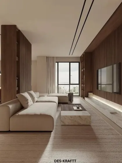 This wide shot captures the full length of the warm minimalist living room, showcasing the custom wood-paneled entertainment wall and integrated bookshelves that provide both style and storage.