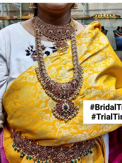 A bridal trial session featuring a grand Kempu (ruby) and stone-studded bridal set. The client is pairing it with her yellow saree to check the final look.